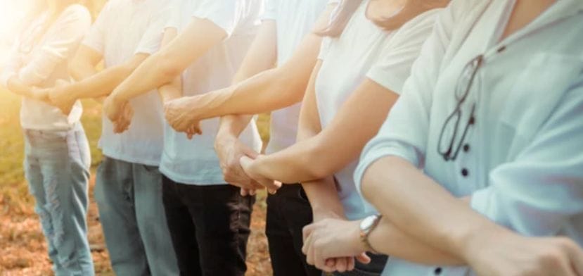 Group of people holding hands, teamwork, collaboration, unity