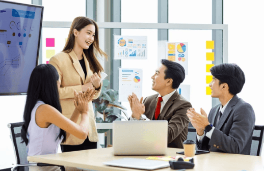 Team applauds new female leader during a presentation.