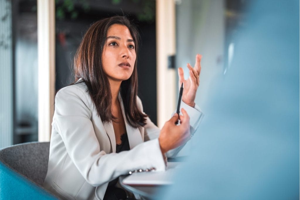Businesswoman in a meeting, thoughtfully discussing ideas.