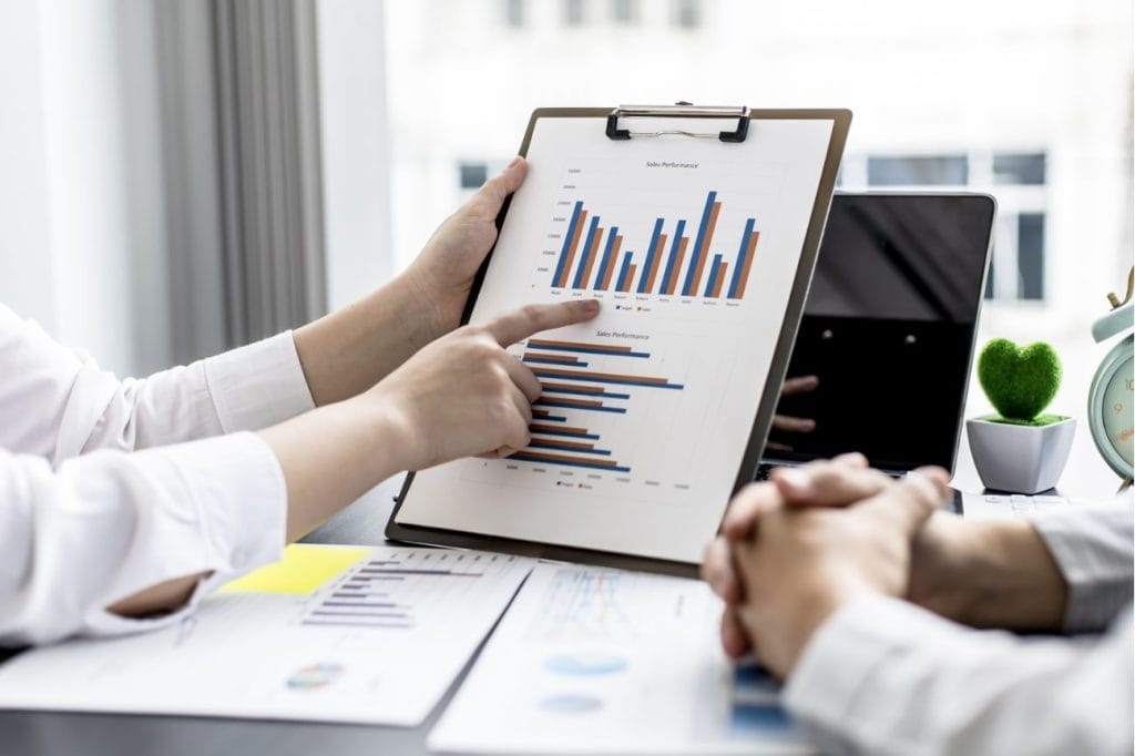 Two businesspeople reviewing sales performance charts and graphs.