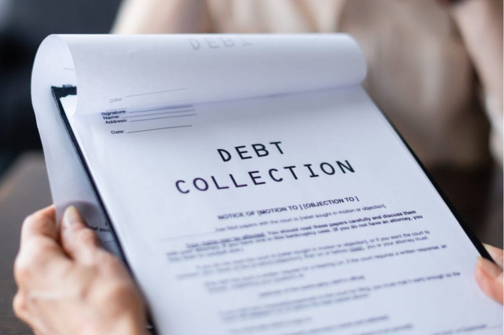 Close-up of hands holding a debt collection notice. The document states "Debt Collection.