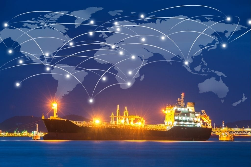 Illuminated oil tanker at night, global shipping network map overlay