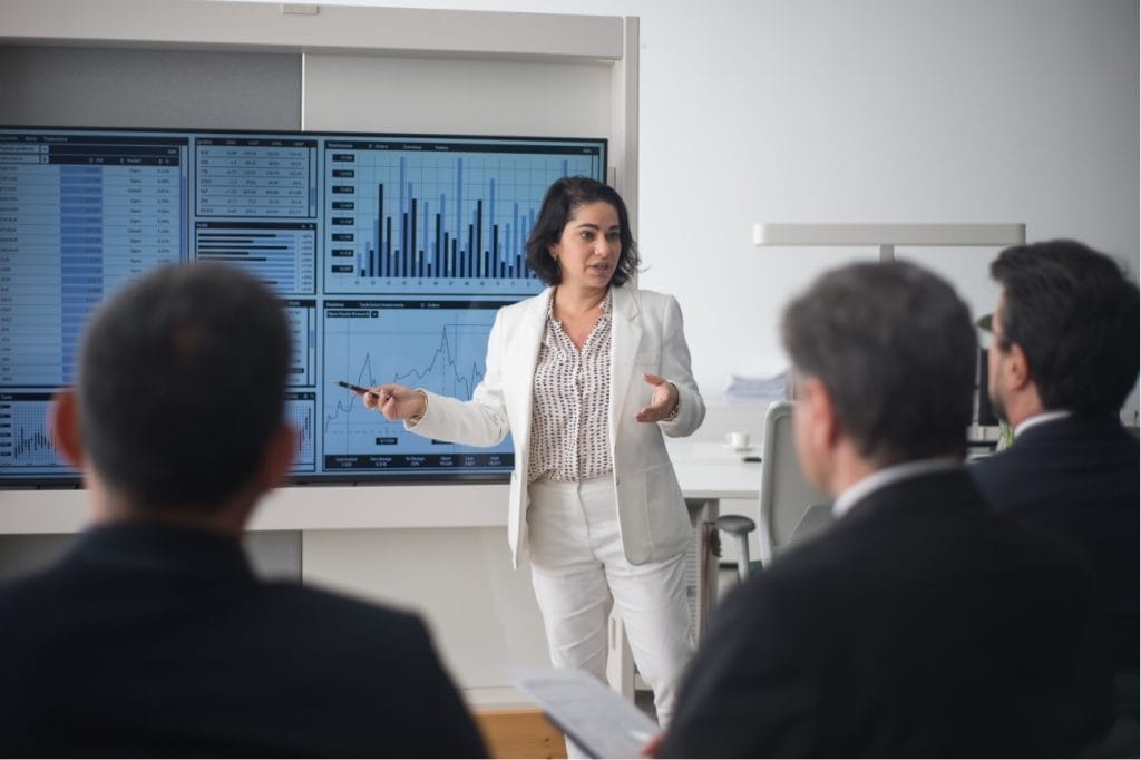 Businesswoman giving a presentation on financial data to colleagues