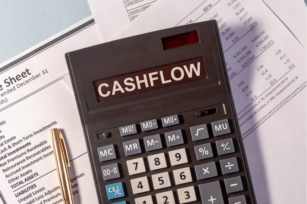 Calculator displaying "CASHFLOW" on financial documents, relevant to Business Education Services.